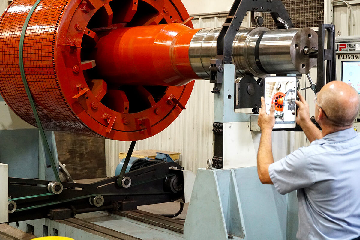 Smith Services staff inspecting motor shaft for machining services